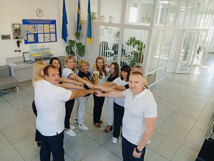 Команда адміністраторів тримаються за руки в колі